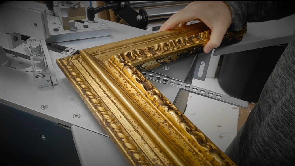 Person holding ornate gold picture frame